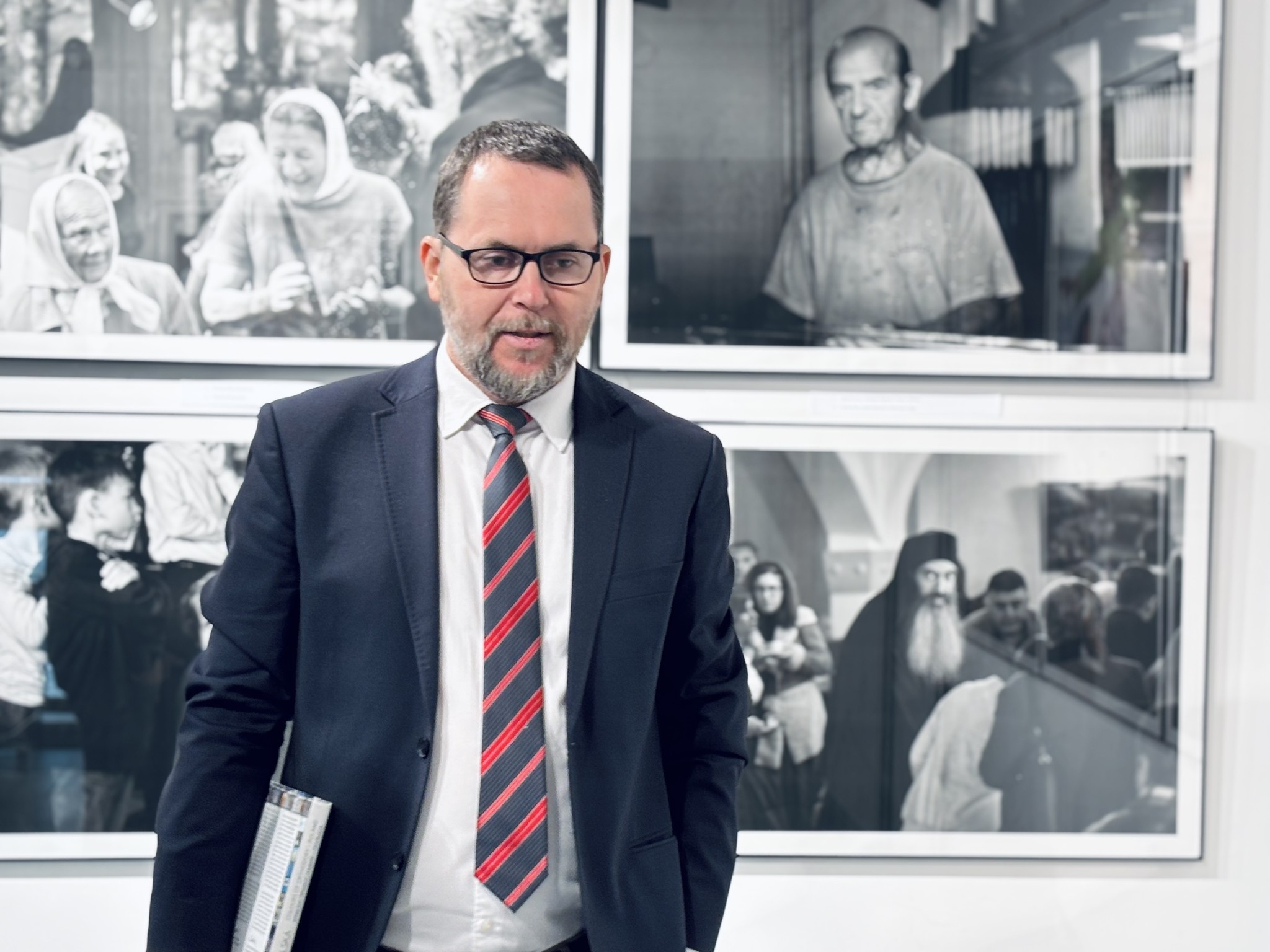 Aleksander Wasyluk na tle swoich fotografii podczas wernisażu w Białej Podlaskiej facebook.com/aleksander.wasyluk